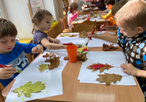 Dzieci stemplują farbą jesienne liście